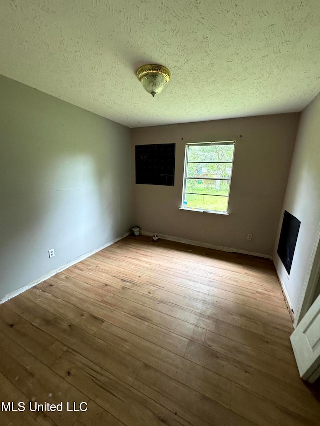 interior space featuring light hardwood / wood-style flooring and a textured ceiling