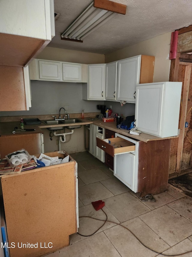 kitchen with sink, white cabinets, and light tile patterned floors