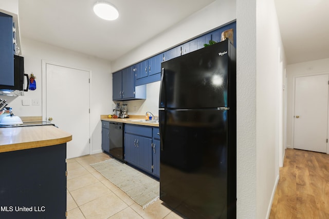 1215 23rd St, Gulfport, MS 39501 - kitchen with black appliances, blue cabinets, light tile patterned floors, and butcher block counters