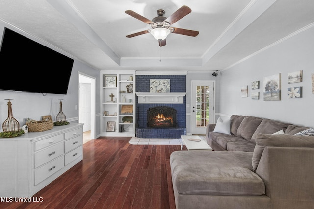 215 Cobblestone Dr, Madison, MS 39110 - living area featuring a tray ceiling, dark wood-style flooring, ceiling fan, a fireplace, and built in features