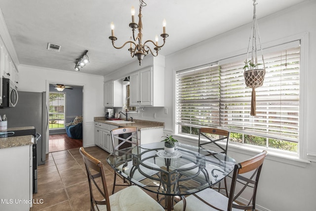 215 Cobblestone Dr, Madison, MS 39110 - dining room featuring dark tile patterned flooring, ornamental molding, a chandelier, and ceiling fan