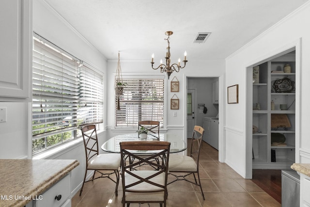 215 Cobblestone Dr, Madison, MS 39110 - tiled dining room with a chandelier, crown molding, and washing machine and clothes dryer