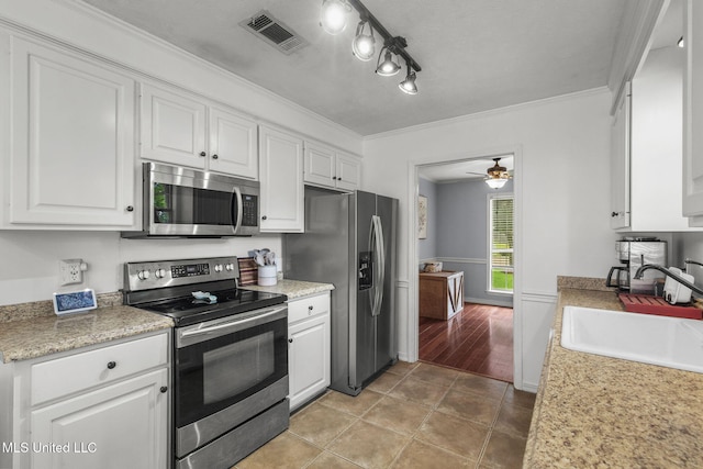 215 Cobblestone Dr, Madison, MS 39110 - kitchen with appliances with stainless steel finishes, white cabinets, light countertops, a ceiling fan, and ornamental molding
