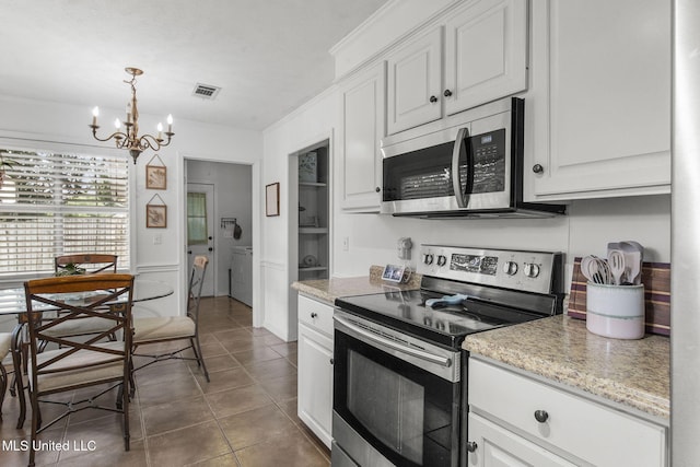 215 Cobblestone Dr, Madison, MS 39110 - kitchen featuring appliances with stainless steel finishes, tile patterned floors, a chandelier, white cabinets, and hanging light fixtures