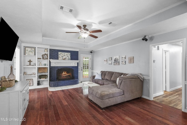 215 Cobblestone Dr, Madison, MS 39110 - living area with a tray ceiling, hardwood / wood-style flooring, a brick fireplace, a ceiling fan, and crown molding