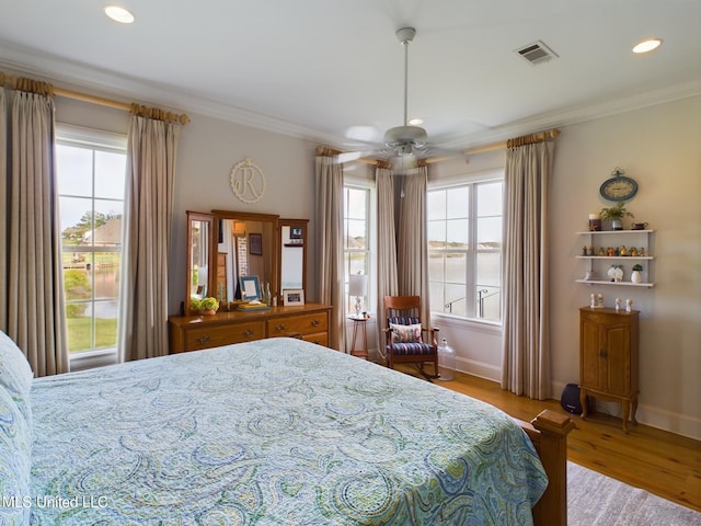 bedroom with ceiling fan, light hardwood / wood-style floors, and ornamental molding