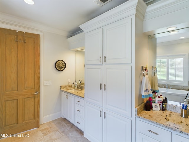 bathroom with tile patterned flooring, vanity, a bathtub, and ornamental molding