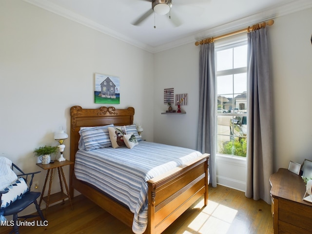 bedroom with ceiling fan, ornamental molding, light hardwood / wood-style flooring, and multiple windows