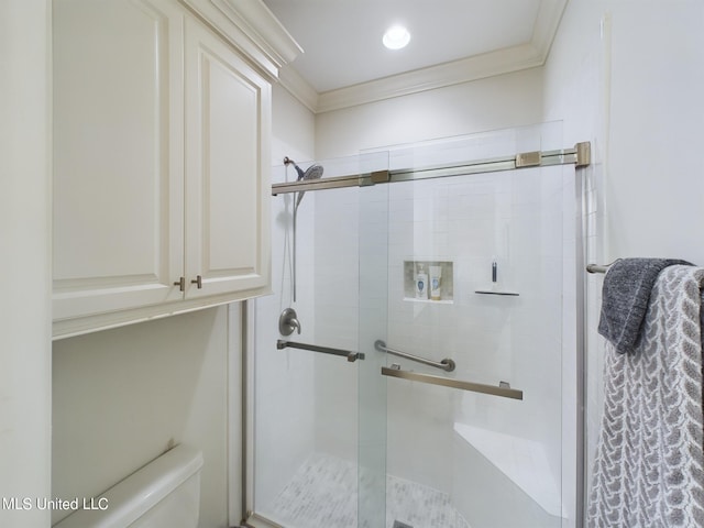 bathroom with a shower with door and ornamental molding