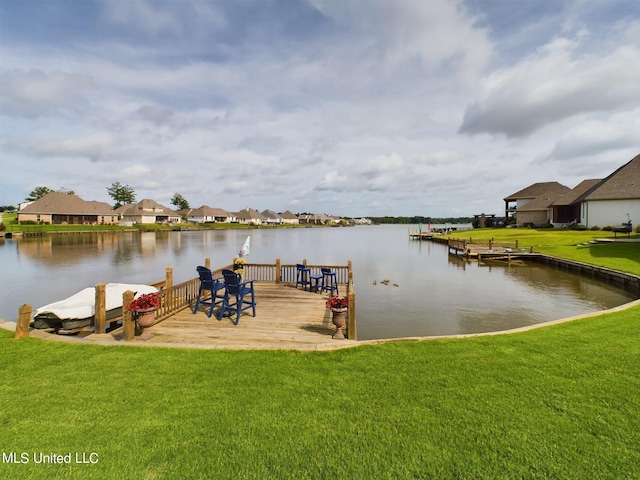 view of dock with a lawn and a water view