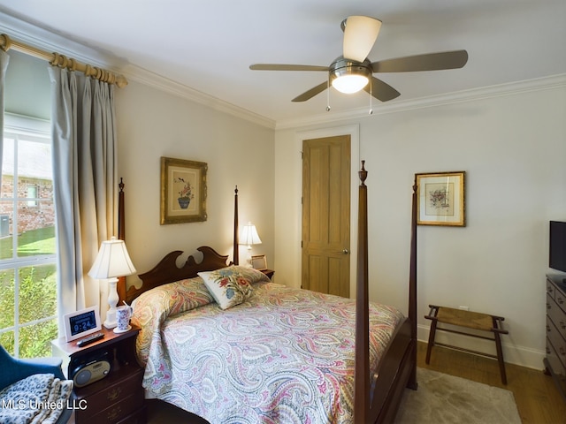 bedroom featuring hardwood / wood-style flooring, ceiling fan, crown molding, and multiple windows