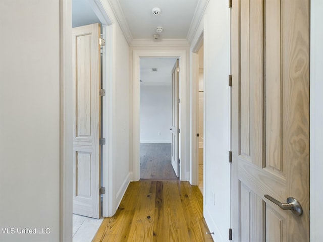 hallway featuring crown molding and light hardwood / wood-style floors