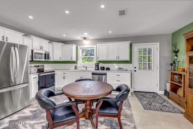 2085 Pat Ln, Biloxi, MS 39531 - kitchen with stainless steel appliances, light countertops, white cabinets, tasteful backsplash, and recessed lighting