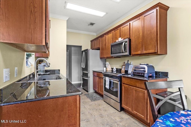 21915 Huntington Forest Dr, Saucier, MS 39574 - kitchen featuring stainless steel appliances, a sink, ornamental molding, brown cabinets, and dark stone countertops