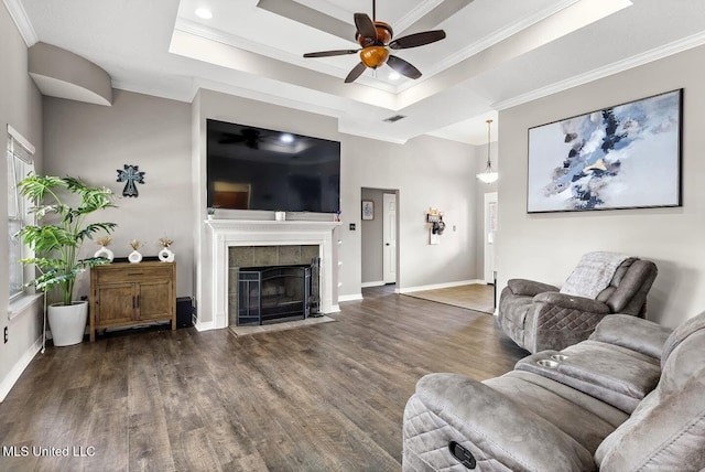 21915 Huntington Forest Dr, Saucier, MS 39574 - living room featuring ceiling fan, wood finished floors, crown molding, a tray ceiling, and a tiled fireplace