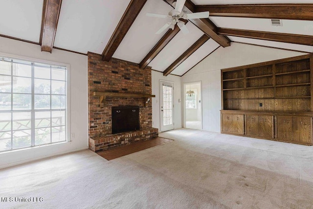 unfurnished living room featuring lofted ceiling with beams, carpet, ceiling fan, and a healthy amount of sunlight