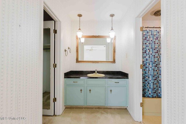 bathroom with wallpapered walls and vanity