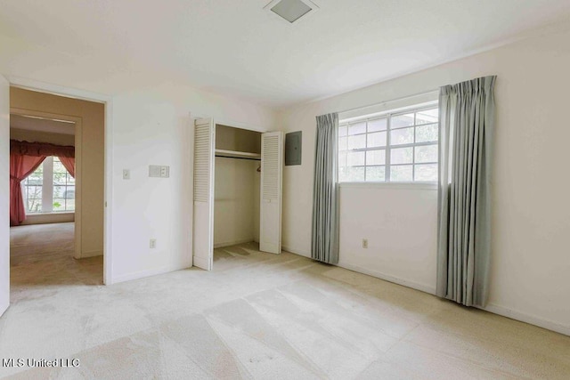 unfurnished bedroom with baseboards, light carpet, and a closet