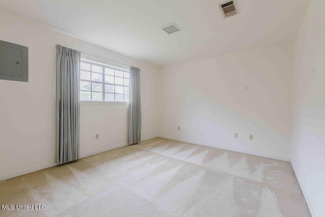 carpeted empty room featuring electric panel and visible vents