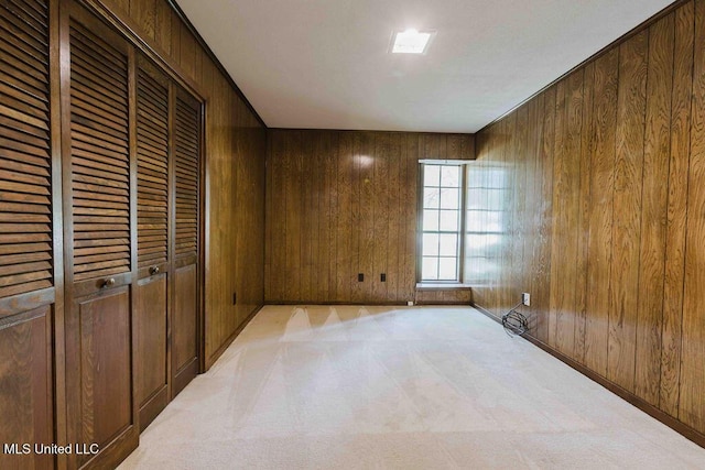 spare room with carpet flooring and wood walls
