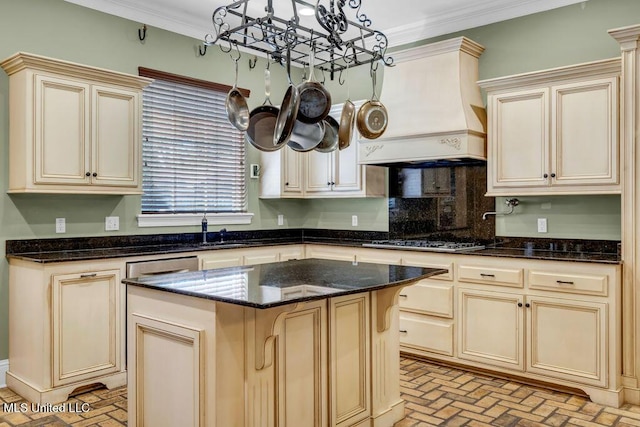 769 Mclane Ln, Biloxi, MS 39532 - kitchen featuring a chandelier, stainless steel gas stovetop, cream cabinetry, premium range hood, and ornamental molding