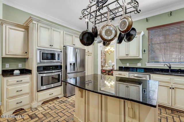 769 Mclane Ln, Biloxi, MS 39532 - kitchen with stainless steel appliances, brick flooring, cream cabinets, a kitchen island, and crown molding