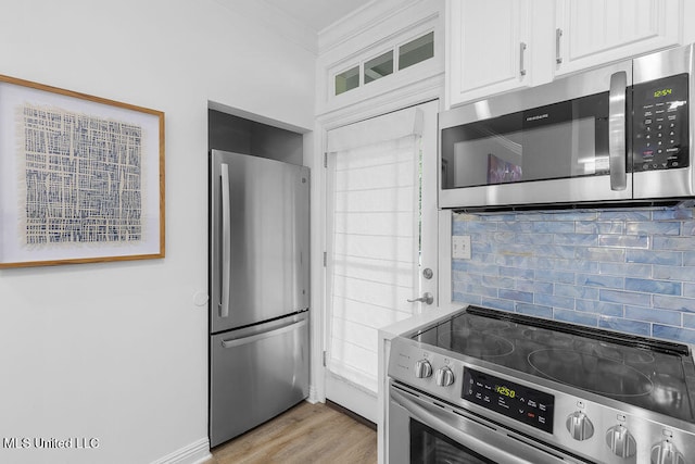 kitchen with white cabinetry, stainless steel appliances, decorative backsplash, and light hardwood / wood-style flooring