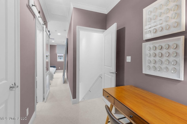 hallway with crown molding and a barn door