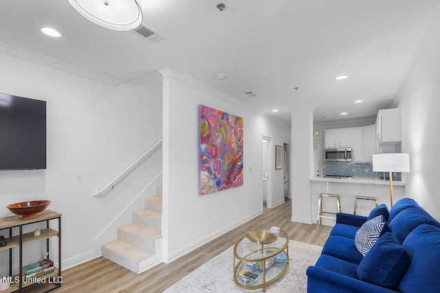 living room featuring light hardwood / wood-style flooring and ornamental molding