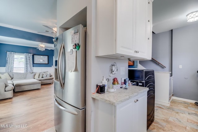 kitchen with ceiling fan, stainless steel refrigerator with ice dispenser, white cabinetry, and open floor plan