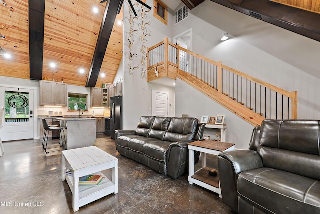 living area with concrete flooring, high vaulted ceiling, wooden ceiling, stairway, and beam ceiling