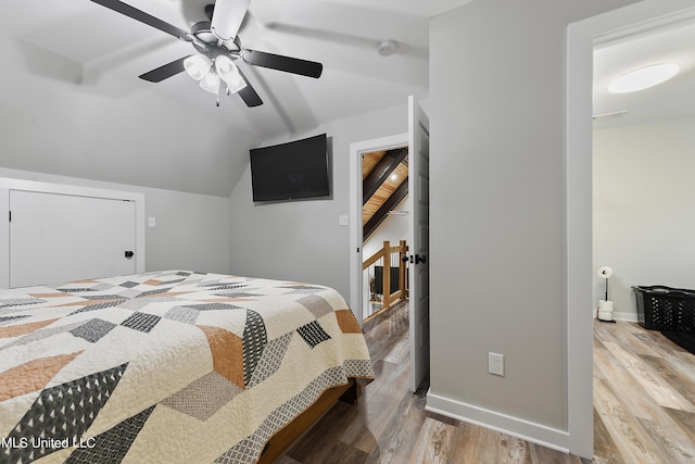 bedroom with lofted ceiling, a ceiling fan, baseboards, and wood finished floors