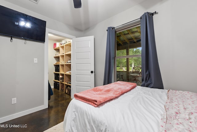 bedroom featuring dark wood-style flooring, ceiling fan, a spacious closet, and baseboards