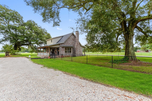 exterior space with a yard, driveway, a chimney, and fence