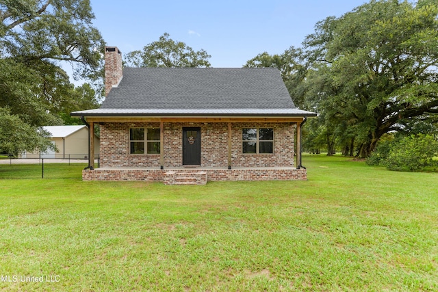 view of front facade with brick siding, fence, a chimney, and a front lawn