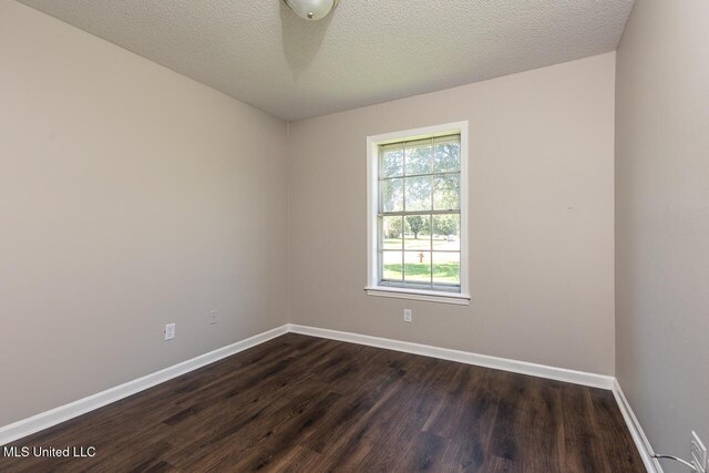 6236 Tulane Rd, Horn Lake, MS 38637 - empty room featuring dark wood finished floors, baseboards, and a textured ceiling