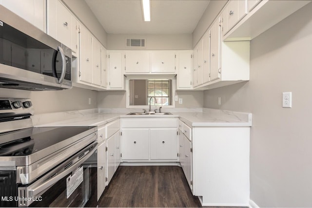 6236 Tulane Rd, Horn Lake, MS 38637 - kitchen with appliances with stainless steel finishes, a sink, dark wood-style flooring, white cabinetry, and light stone countertops