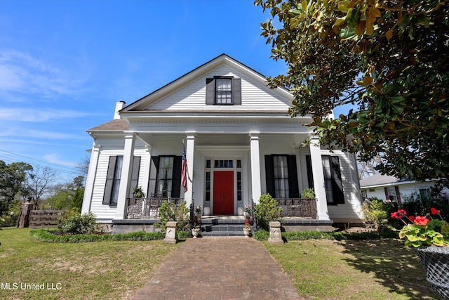 greek revival inspired property with covered porch and a front yard