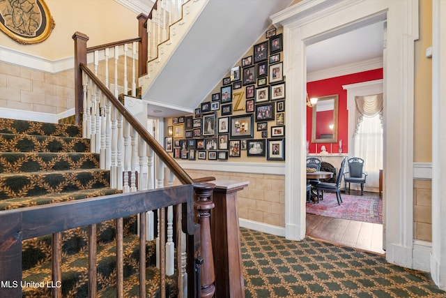 stairway featuring ornamental molding and tile walls