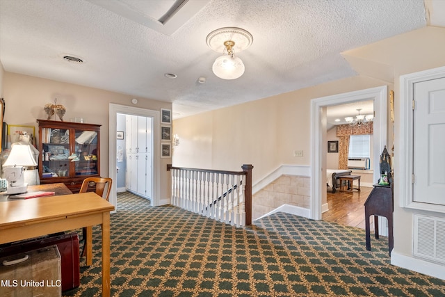 home office featuring a chandelier, light carpet, and a textured ceiling