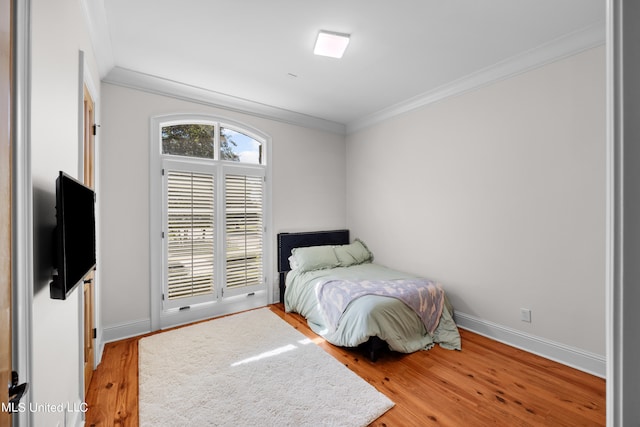 bedroom featuring crown molding and light wood-type flooring