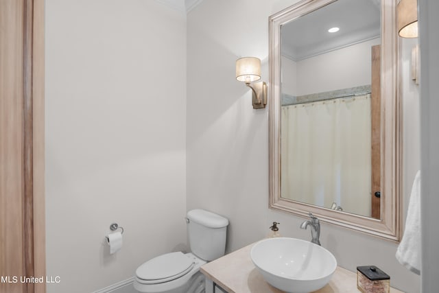 bathroom featuring vanity, toilet, and crown molding