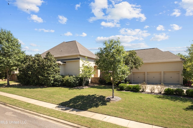 view of front of property featuring a front yard and a garage