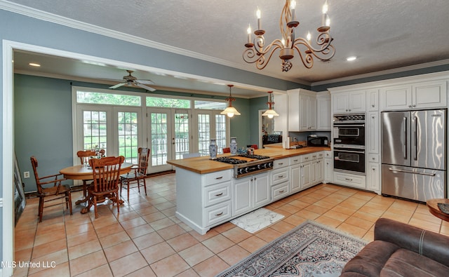 kitchen featuring wooden counters, crown molding, appliances with stainless steel finishes, and white cabinets