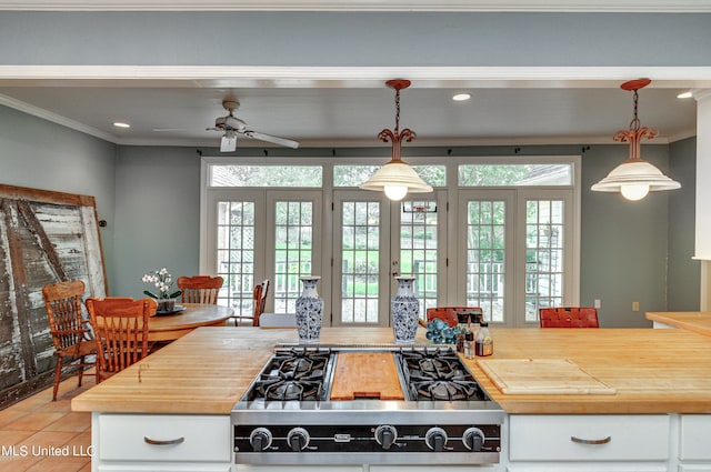 kitchen featuring crown molding, butcher block countertops, pendant lighting, and light tile patterned floors