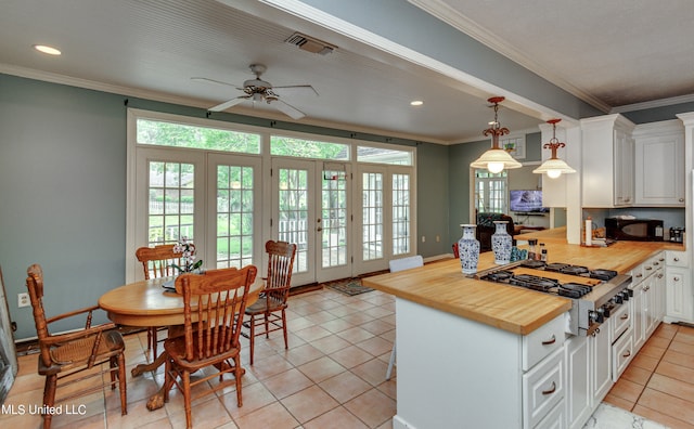 kitchen with french doors, hanging light fixtures, kitchen peninsula, white cabinets, and butcher block countertops