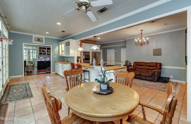 dining space featuring sink, crown molding, light tile patterned floors, and ceiling fan with notable chandelier