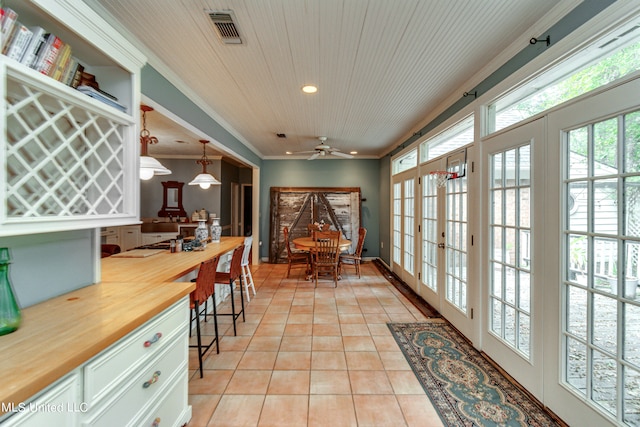 office space with french doors, wooden ceiling, ornamental molding, light tile patterned floors, and ceiling fan