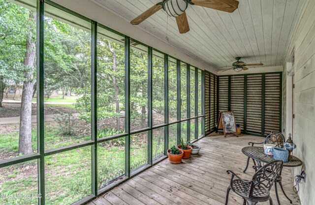 unfurnished sunroom featuring wood ceiling and ceiling fan