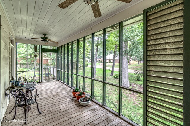 sunroom / solarium with wood ceiling, lofted ceiling, and ceiling fan